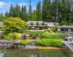 The curvature of the shoreline is mirrored by the home allowing breathtaking water views across the stone, covered patio, lawn and gardens.