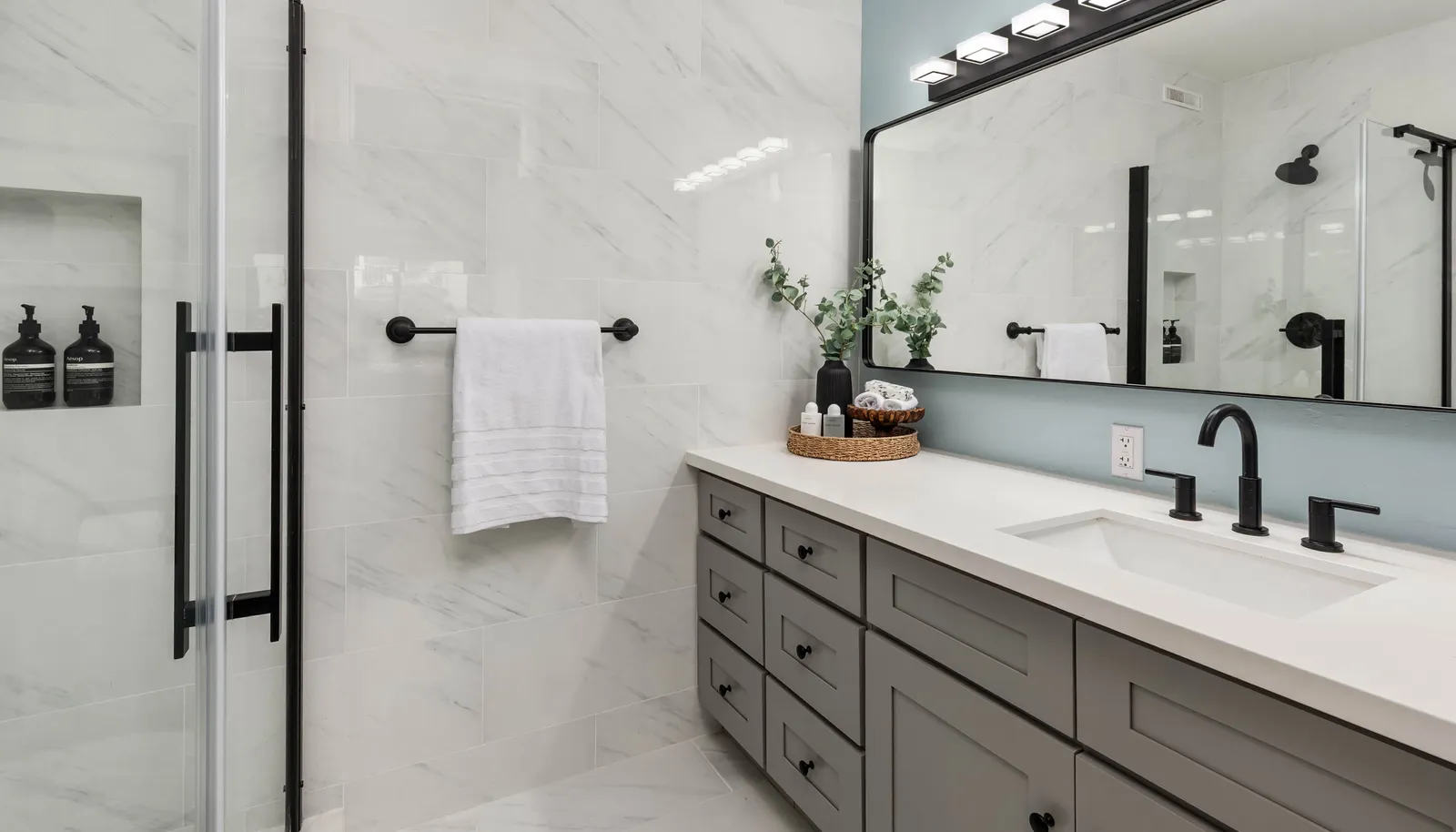 Primary en-suite bathroom featuring a spacious counter, a walk-in shower, and direct access from the primary bedroom.