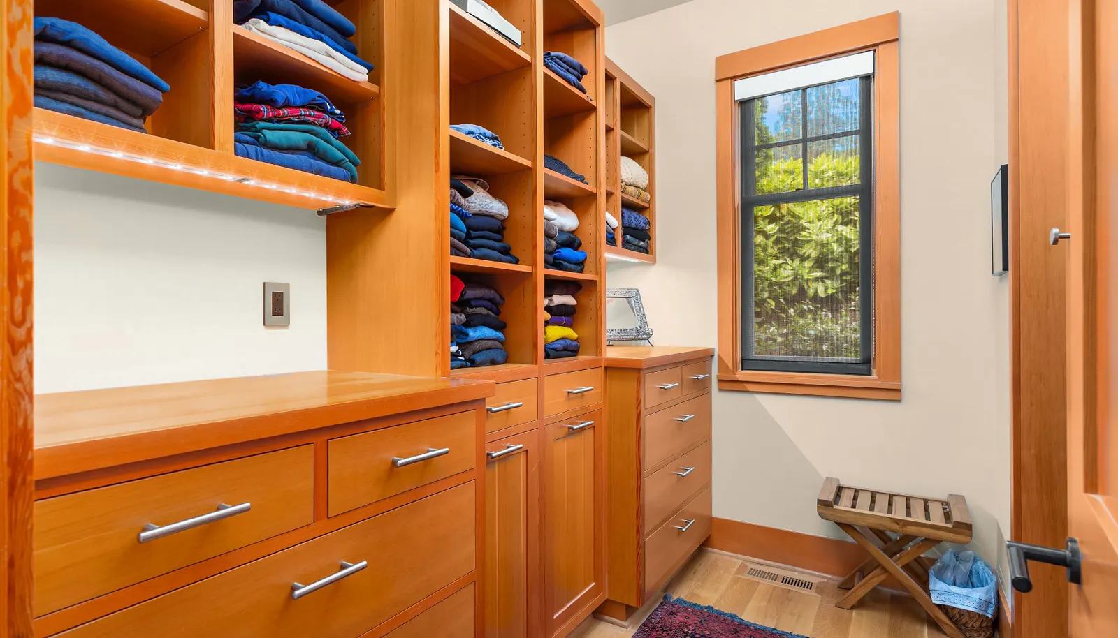The primary closet with custom built-ins and more space to the right. And who doesn't love a closet with a window! 