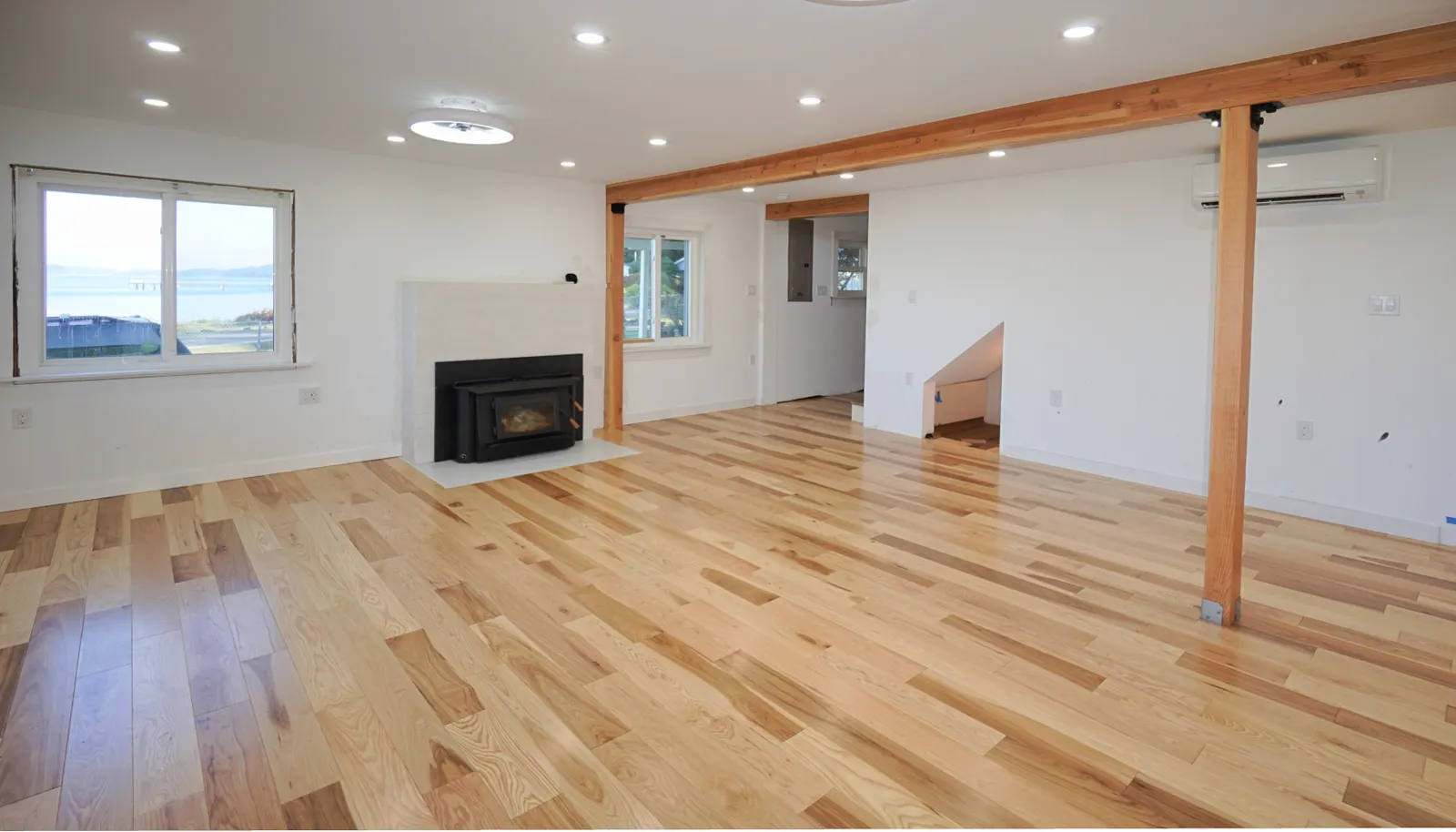 Living room with wood stove and spectacular views. doorway leads to the stairway up and the to the back entry near the driveway.