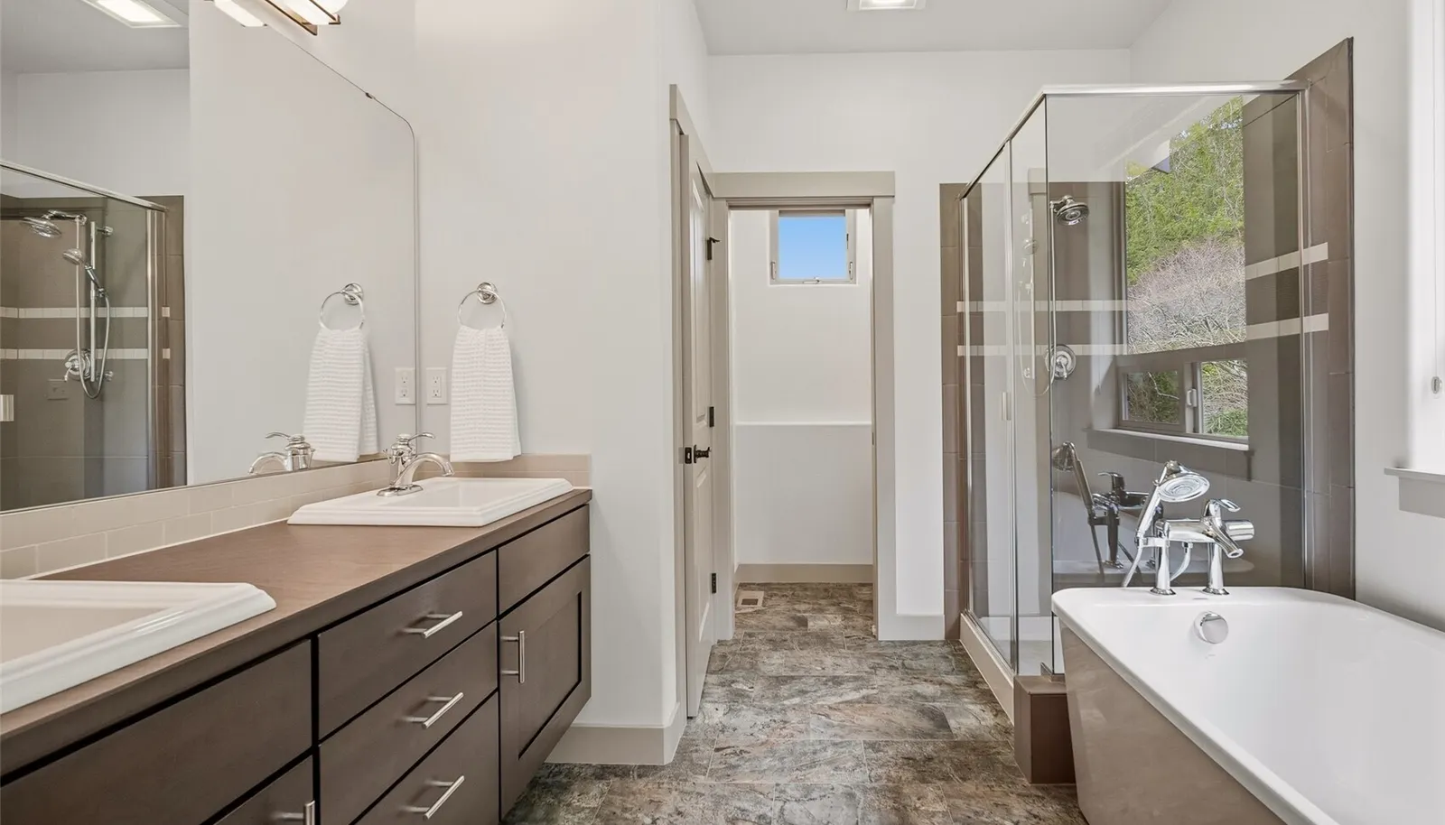 Spa-like bath with double vanity, soaking tub, and separate shower.