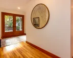The foyer with French doors and white oak floors. There is a coat closet and powder room upon entry on the left.