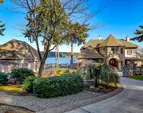 Circular drive, gorgeous landscaping, and water views in all directions!