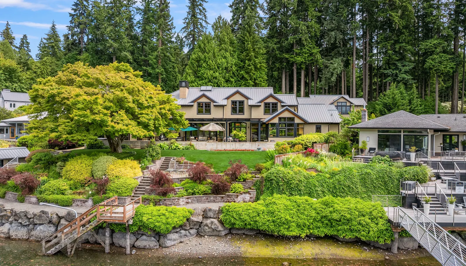 The curvature of the shoreline is mirrored by the home allowing breathtaking water views across the stone, covered patio, lawn and gardens.