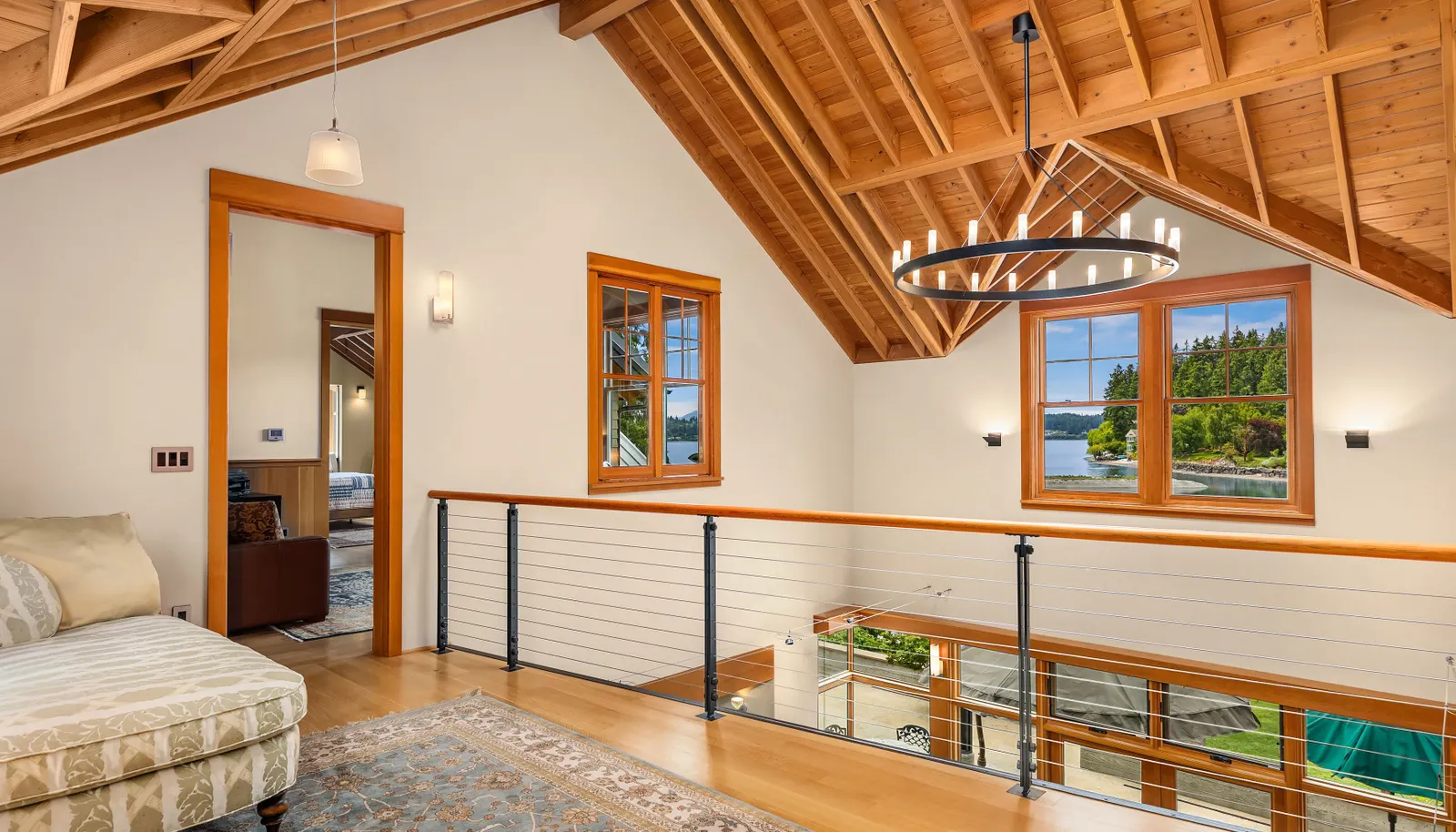 The upper level landing is open to the two story living room, designed to capture the ever changing, dramatic water views
