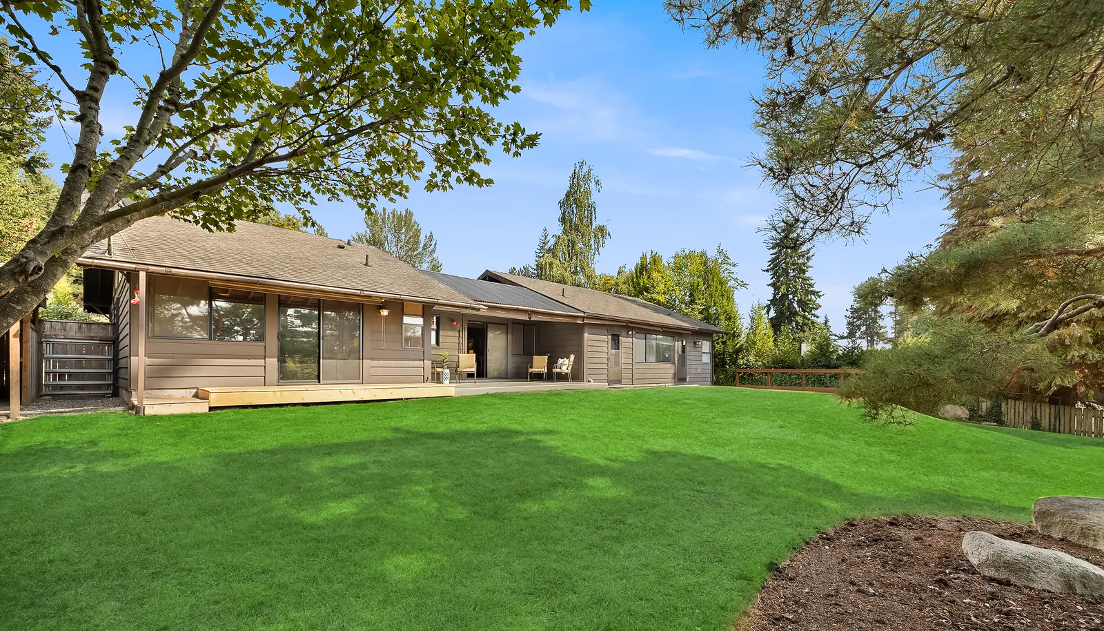 This is a view of the backyard showing a large lawn (it is now seasonally brown). The backyard is fenced. This is a view of the backyard showing a large lawn (it is now seasonally brown). The backyard is fenced.