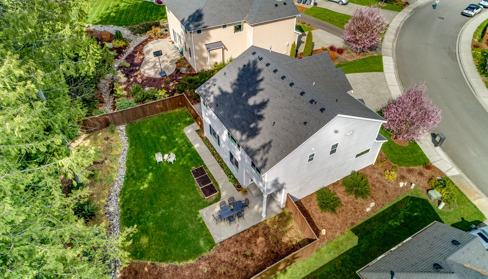 HUGE, private, fully fenced backyard with lush lawn, planter boxes, and your own little forest!