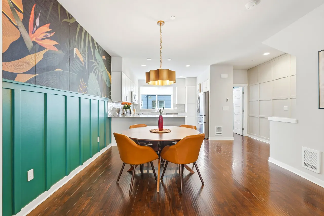 The dining area features an upgraded light fixture and a striking wallpaper, an eye-catching focal point full of personality.