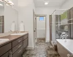 Spa-like bath with double vanity, soaking tub, and separate shower.