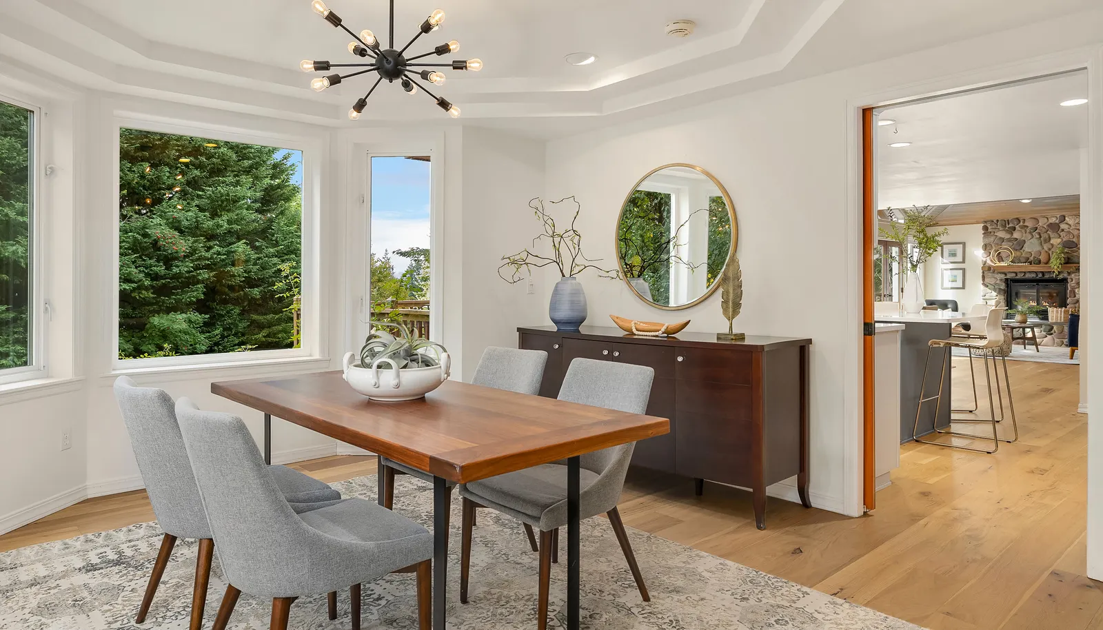 Dining room off the living room has bay windows and a tray ceiling creating an open atmosphere.