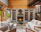 The two story living room is anchored by a stone surround fireplace.