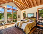 The primary suite with easy access to the hot tub has automatic blinds and gorgeous built-ins