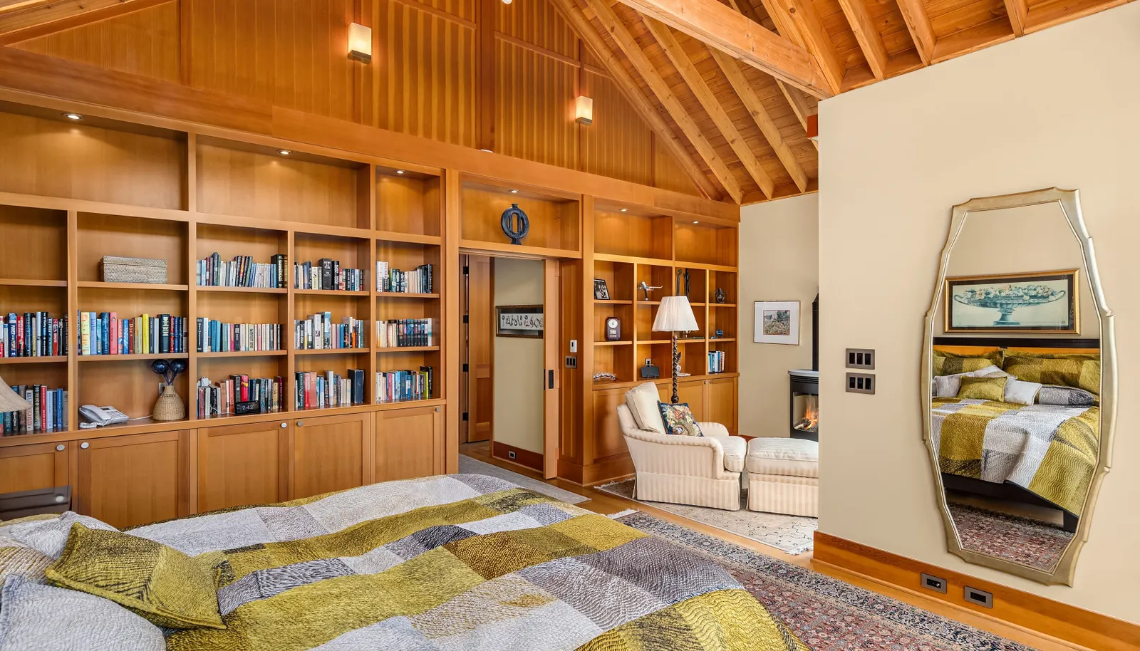 The primary suite looking toward the sitting area to the right and the en-suite bath, walk-in closet and extra washer-dryer are just beyond the pocket doors. 