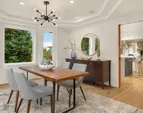 Dining room off the living room has bay windows and a tray ceiling creating an open atmosphere.