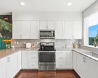 The functional kitchen features crisp white cabinetry, clean lines and efficient layout.
