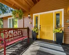 Large, covered front porch with sunny front door invites you in.