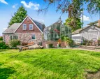 Side yard, greenhouse with stone patio, and storage shed. Side yard, greenhouse with stone patio, and storage shed.