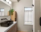 The updated bathroom makes a memorable statement with a shower wrapped in textured concrete walls