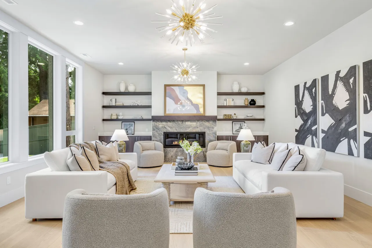 Custom built-in shelves and cabinets, dual chandeliers, and a modern fireplace with TV hookup.