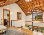 The upper level landing is open to the two story living room, designed to capture the ever changing, dramatic water views