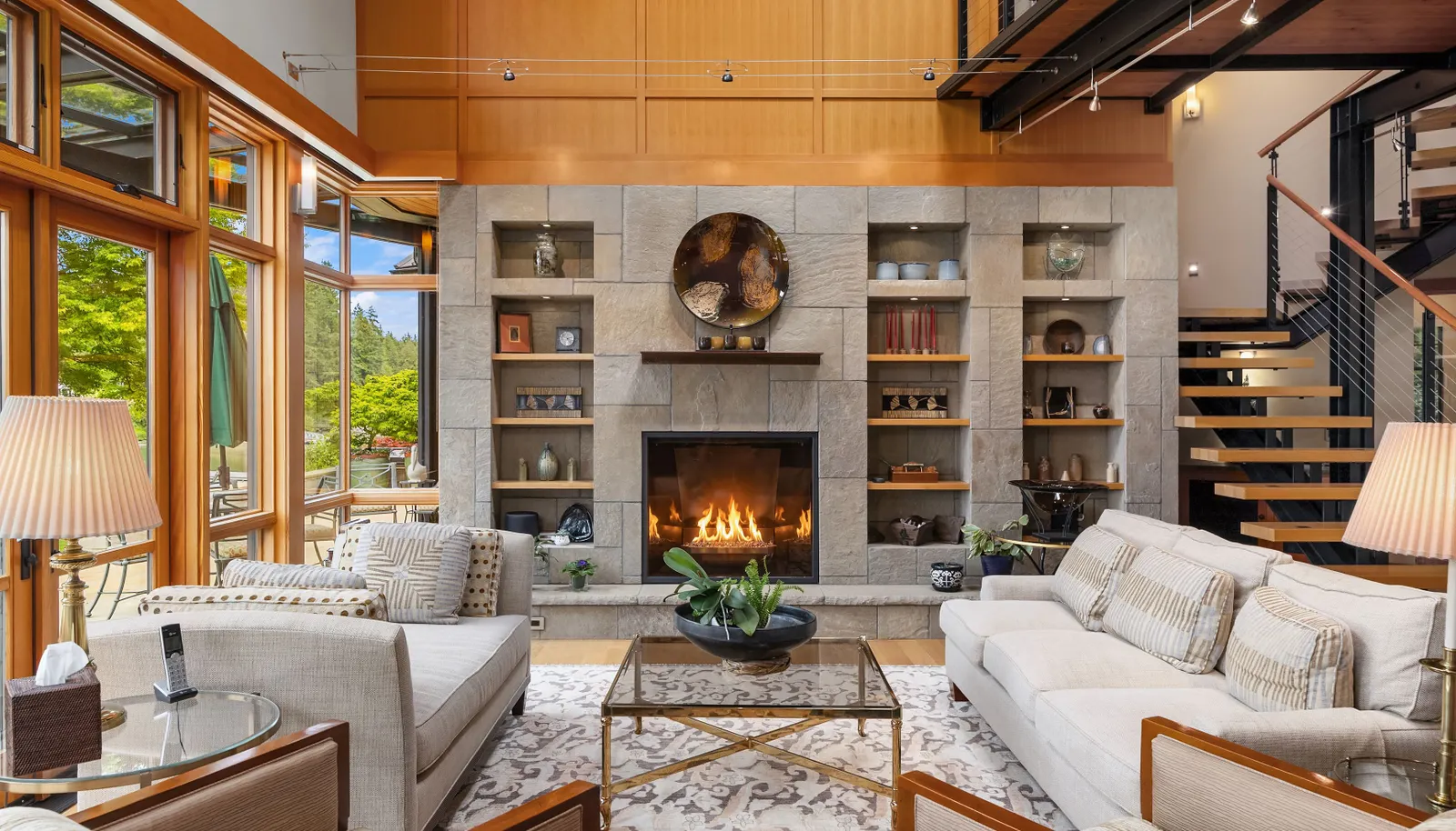The two story living room is anchored by a stone surround fireplace.