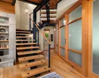 Steel beam construction is balanced with warm wood. A timeless architectural balance. The cozy den/TV room is behind the frosted glass curved wall