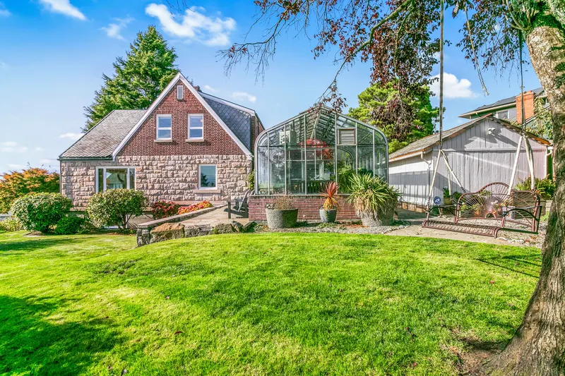 Side yard, greenhouse with stone patio, and storage shed. Side yard, greenhouse with stone patio, and storage shed.