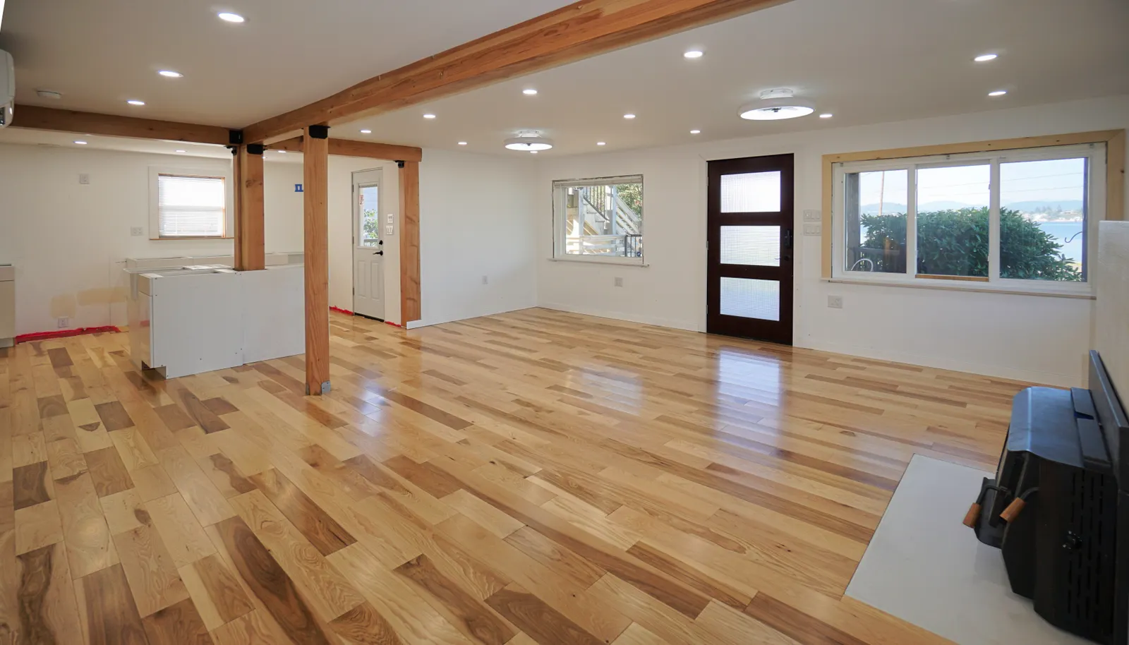 Main floor flooring and kitchen installation ongoing to the left.