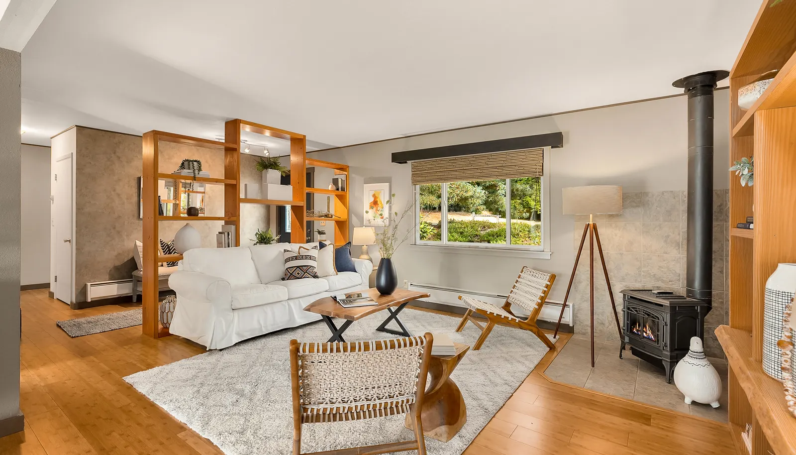 The living room has built-in shelves, a propane free-standing stove, bamboo floors, and is open to the dining area. The living room has built-in shelves, a propane free-standing stove, bamboo floors, and is open to the dining area.