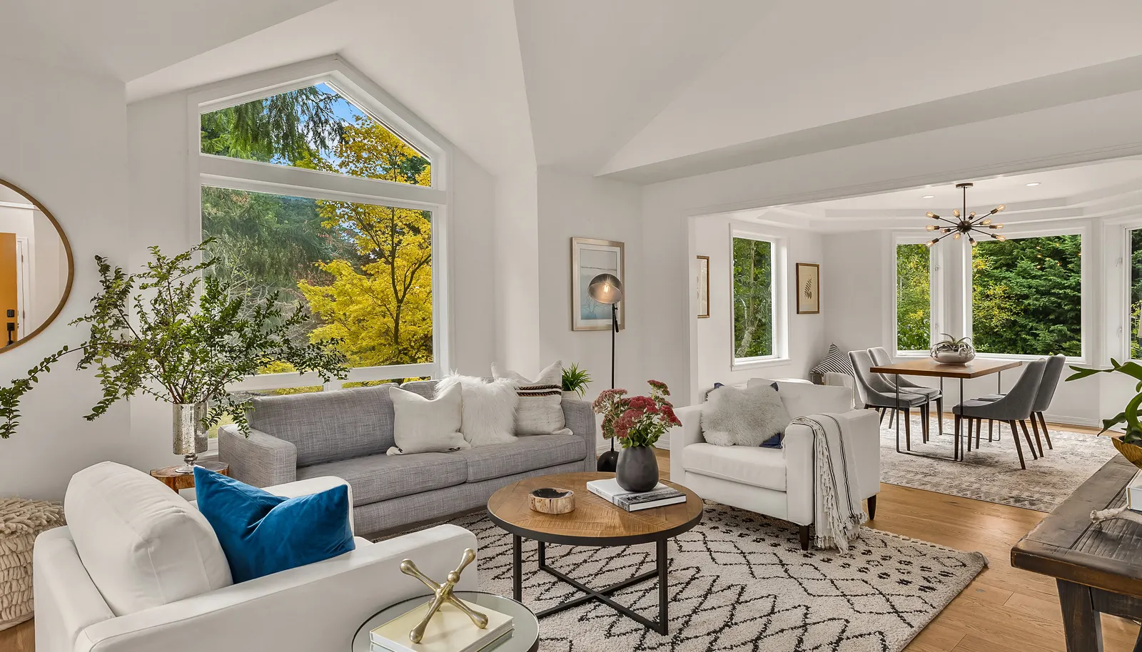 This view of the living room shows off the massive picture window and vaulted ceiling adding to the open feel of the space. All new wood flooring completes throughout lower level.