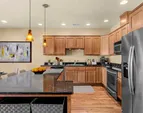 Gourmet kitchen with warm wood cabinetry, full appliance suite, and ample counter space