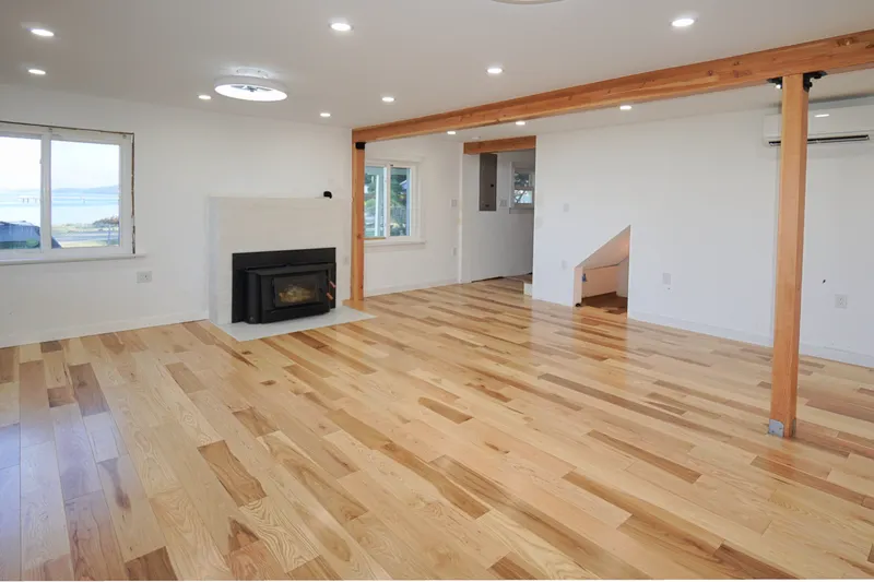 Living room with wood stove and spectacular views. doorway leads to the stairway up and the to the back entry near the driveway.