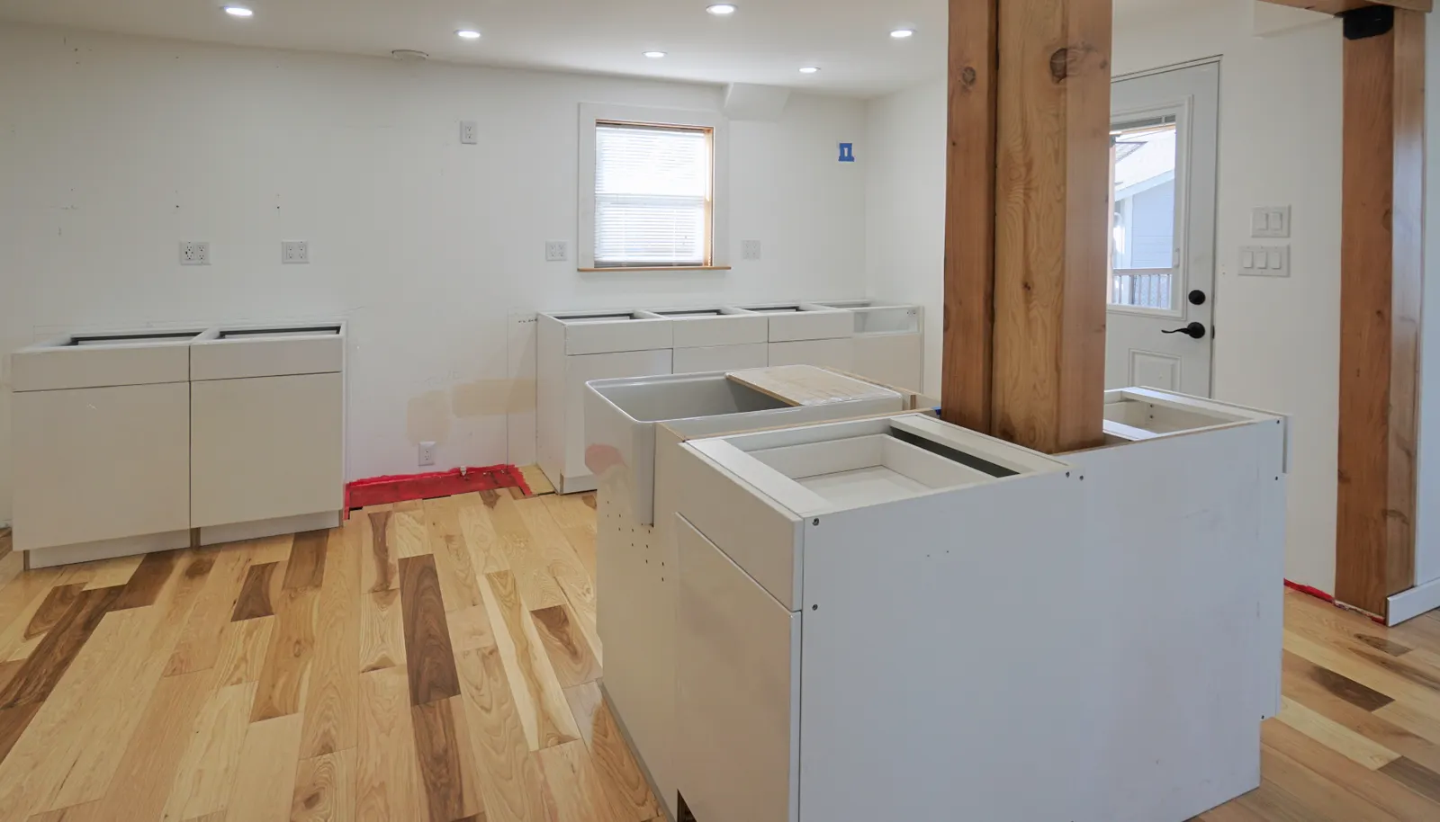Kitchen island with plantation sink will have quartz countertops and a dishwasher on the far side. Base cabinets will have uppers along the wall, to be installed soon.