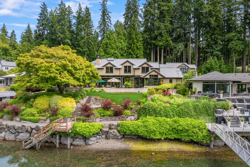 The curvature of the shoreline is mirrored by the home allowing breathtaking water views across the stone, covered patio, lawn and gardens.