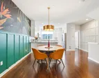 The dining area features an upgraded light fixture and a striking wallpaper, an eye-catching focal point full of personality.