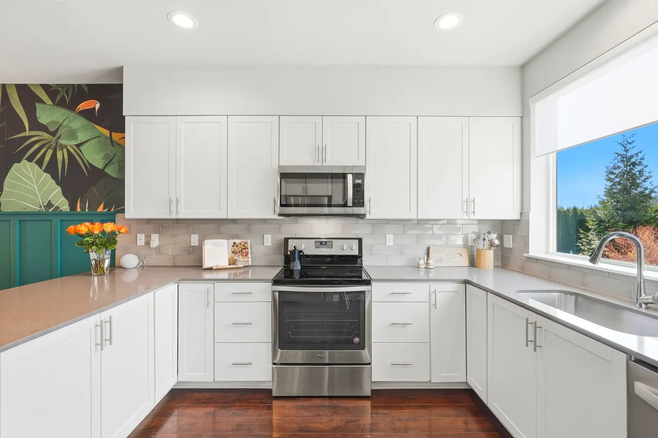 The functional kitchen features crisp white cabinetry, clean lines and efficient layout.