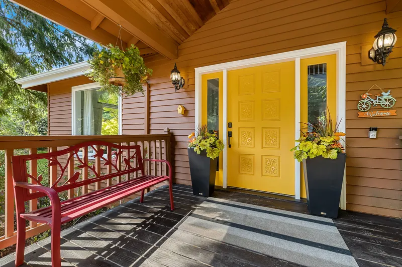 Large, covered front porch with sunny front door invites you in.