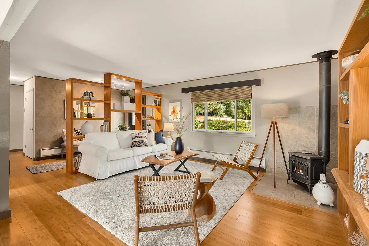 The living room has built-in shelves, a propane free-standing stove, bamboo floors, and is open to the dining area. The living room has built-in shelves, a propane free-standing stove, bamboo floors, and is open to the dining area.